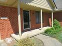 Cozy covered front porch with brick columns, a glass front door, and manicured shrubbery at 2996 Colony Lake W Dr, Plainfield, IN 46168