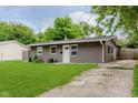 Quaint single-story home featuring a lush front lawn and adjacent driveway at 3149 Thayer St, Indianapolis, IN 46222