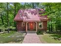 Inviting log cabin with red roof, decorative flower boxes and a charming wooden walkway at 3715 Orchard Rd, Columbus, IN 47201