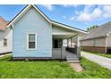 Exterior angle of blue home featuring covered front porch and gray brick foundation at 410 Montgomery St, Shelbyville, IN 46176