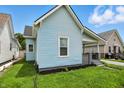 Angle of home showcasing light blue siding, adjacent houses and green foliage at 410 Montgomery St, Shelbyville, IN 46176