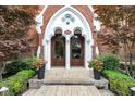 Elegant entryway with brick archway, double doors, address number, and manicured landscaping at 501 Fletcher Ave # A, Indianapolis, IN 46203