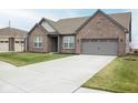 Charming brick home featuring an attached two-car garage, green lawn, and concrete driveway at 5081 Holborn Ave, McCordsville, IN 46055