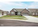 Charming brick home featuring an attached two-car garage, green lawn, and well-kept landscaping at 5081 Holborn Ave, McCordsville, IN 46055