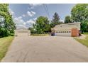 Home with a detached garage and ample parking space on the paved driveway at 5226 W Southport Rd, Indianapolis, IN 46221