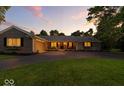 Evening shot of ranch home with brick accents and warm interior lights at 5850 E 54Th Pl, Indianapolis, IN 46226