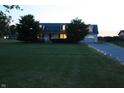 Exterior view of home, including landscaping and driveway lighting, at dusk at 6052 N Deckshire Ln, Shirley, IN 47384