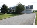 Exterior view of white home featuring an attached garage and a long gravel driveway at 6052 N Deckshire Ln, Shirley, IN 47384