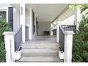 Inviting covered front porch with classic railing and concrete steps at 633 N East St, Greenfield, IN 46140