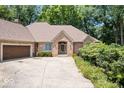 Charming brick ranch with manicured lawn, mature trees, and attached two-car garage at 7250 Royal Oakland Dr, Indianapolis, IN 46236