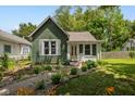 Charming home with well-maintained landscaping, green siding and inviting pathway to the front door at 761 N Holmes Ave, Indianapolis, IN 46222