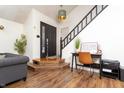 Entryway with wood floors, a black front door, and a staircase at 7612 Farm View E Cir, Indianapolis, IN 46256