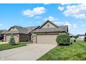 Inviting home exterior with well-manicured lawn, mature landscaping, and an attached two-car garage at 785 Cottage Ln, Greenwood, IN 46143