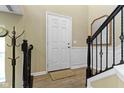 Inviting foyer with hardwood floors, coat rack, and staircase at 9476 Oakley Dr, Indianapolis, IN 46260