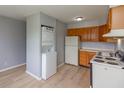 Functional kitchen with wooden cabinets, white appliances, and convenient washer/dryer unit at 951 W Mckay Rd, Shelbyville, IN 46176