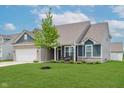 Stylish home with green lawn, covered front porch, and tasteful architectural details at 9806 Olympic Blvd, Pendleton, IN 46064