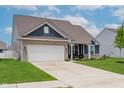 A beautiful home featuring a two-car garage, well-kept lawn and attractive siding details at 9806 Olympic Blvd, Pendleton, IN 46064