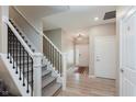 Inviting foyer with staircase, light wood floors, and views to the front door at 9806 Olympic Blvd, Pendleton, IN 46064