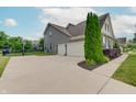 View of three-car garage, basketball hoop and a well-maintained lawn and landscaping at 10107 Landis Blvd, Fishers, IN 46040