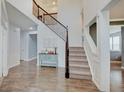 Bright, two-story foyer with hardwood floors, staircase, and wainscoting details at 10107 Landis Blvd, Fishers, IN 46040