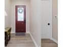 Welcoming entryway with a decorative wreath on a red door, complemented by modern flooring at 10725 Crum Ct, Fishers, IN 46037
