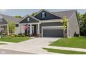 Inviting gray home featuring a two-car garage, a well-maintained lawn, and an American flag displayed at 10725 Crum Ct, Fishers, IN 46037