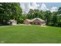 A well-maintained lawn surrounds a beautiful brick house with a detached garage on a sunny day at 1125 Observatory Rd, Martinsville, IN 46151