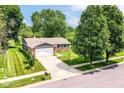 Aerial view of a home with well-kept lawn, a two-car garage, and mature trees at 12020 Colbarn Dr, Fishers, IN 46038