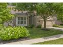 Inviting brick home with lush landscaping, a mature tree in front, and a convenient two-car garage at 13172 Duval Dr, Fishers, IN 46037