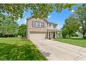 Inviting two-story home with a combination brick and vinyl exterior, attached garage, front porch, and a large front yard at 14754 Drayton Dr, Noblesville, IN 46062