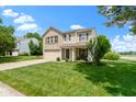 Charming two-story home featuring a brick and vinyl exterior, attached garage, front porch, and a lush green lawn at 14754 Drayton Dr, Noblesville, IN 46062
