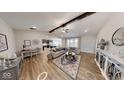 Inviting living room featuring wood floors, a ceiling fan, comfortable seating, and an open view to the kitchen at 1550 Fox Hollow Dr, Martinsville, IN 46151