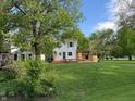 Spacious backyard featuring a large lawn, mature trees, and a custom wooden deck perfect for outdoor entertaining at 1738 E 71St St, Indianapolis, IN 46220
