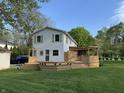 Back of house with a custom wood deck featuring tiered levels, built-in seating, and stylish privacy fencing at 1738 E 71St St, Indianapolis, IN 46220
