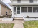 Home exterior showcasing a landscaped yard, a porch and white walls and pillars at 3936 Graceland Ave, Indianapolis, IN 46208