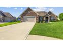Charming home featuring an attached garage and a well-maintained lawn at 5220 Orahood Ct, Plainfield, IN 46168