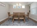 Bright dining room with a wooden table, six chairs, and stylish light fixture at 5351 Rose Dr, Zionsville, IN 46077