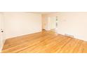 Bright living room with gleaming hardwood floors, neutral walls, and access to other rooms at 5803 Schoolwood Dr, Speedway, IN 46224