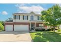 Two-story home with a two-car garage, brick accents, a well-manicured lawn, and a charming front porch at 6045 Copeland Mills Ct, Indianapolis, IN 46221