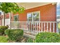 Inviting front porch with red brick, white railings, and manicured bushes and flowers at 6045 Copeland Mills Ct, Indianapolis, IN 46221