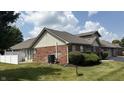 Brick-exterior home with a manicured lawn, offering a cozy outdoor living space at 6139 Robinwood Dr, Indianapolis, IN 46237