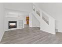 Bright living room featuring sleek gray flooring, a modern fireplace, and staircase at 618 Stobus Dr, Greenwood, IN 46143