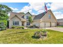 Attractive brick home showcasing a lush green lawn and beautiful landscaping on a sunny day at 6686 Woodcrest Dr, Avon, IN 46123