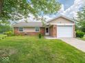 Charming single-story home with a brick facade, attached garage, and well-maintained front lawn at 7645 Inverness Dr, Indianapolis, IN 46237