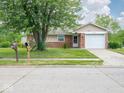 Charming single-story home with a brick facade, attached garage, and well-maintained front lawn at 7645 Inverness Dr, Indianapolis, IN 46237