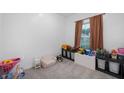 Bright, carpeted bedroom with natural light and decorated with many toys and places to store them at 77 Winding Brook Way, Pendleton, IN 46064