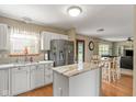 Bright eat-in kitchen featuring an island with stone countertop, modern appliances, and wood flooring at 787 West St, Whiteland, IN 46184