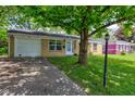 Single story brick home featuring a well-manicured lawn and paved driveway at 8540 E 37Th Pl, Indianapolis, IN 46226