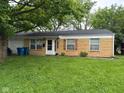Charming brick ranch-style home with a well-maintained lawn, quaint shutters, and attached garage at 8540 E 37Th Pl, Indianapolis, IN 46226