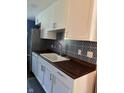 Modern kitchen features white cabinets, dark countertops, stainless steel appliances, and decorative backsplash at 8540 E 37Th Pl, Indianapolis, IN 46226